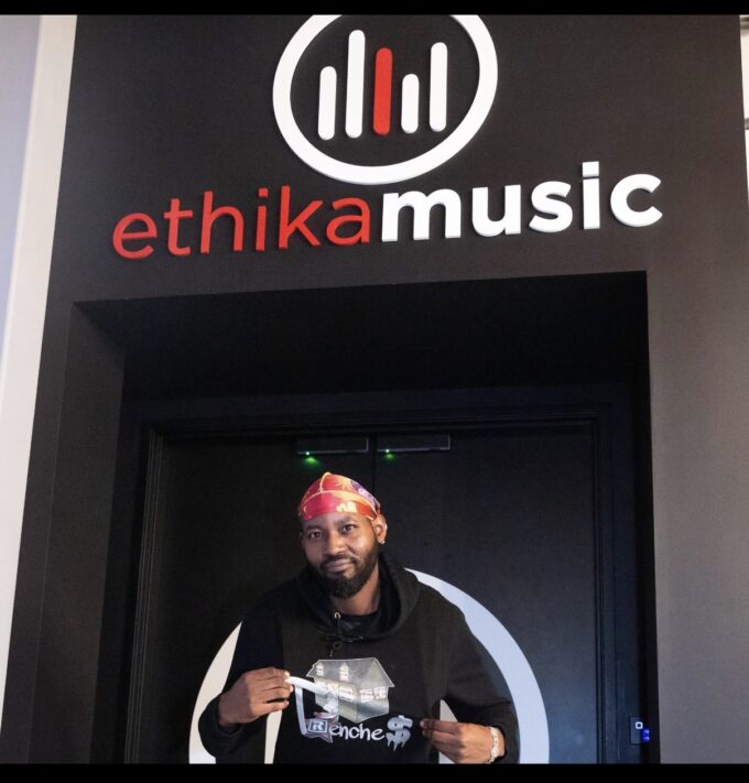 Flyboi Rich wearing a black hoodie and colorful head covering